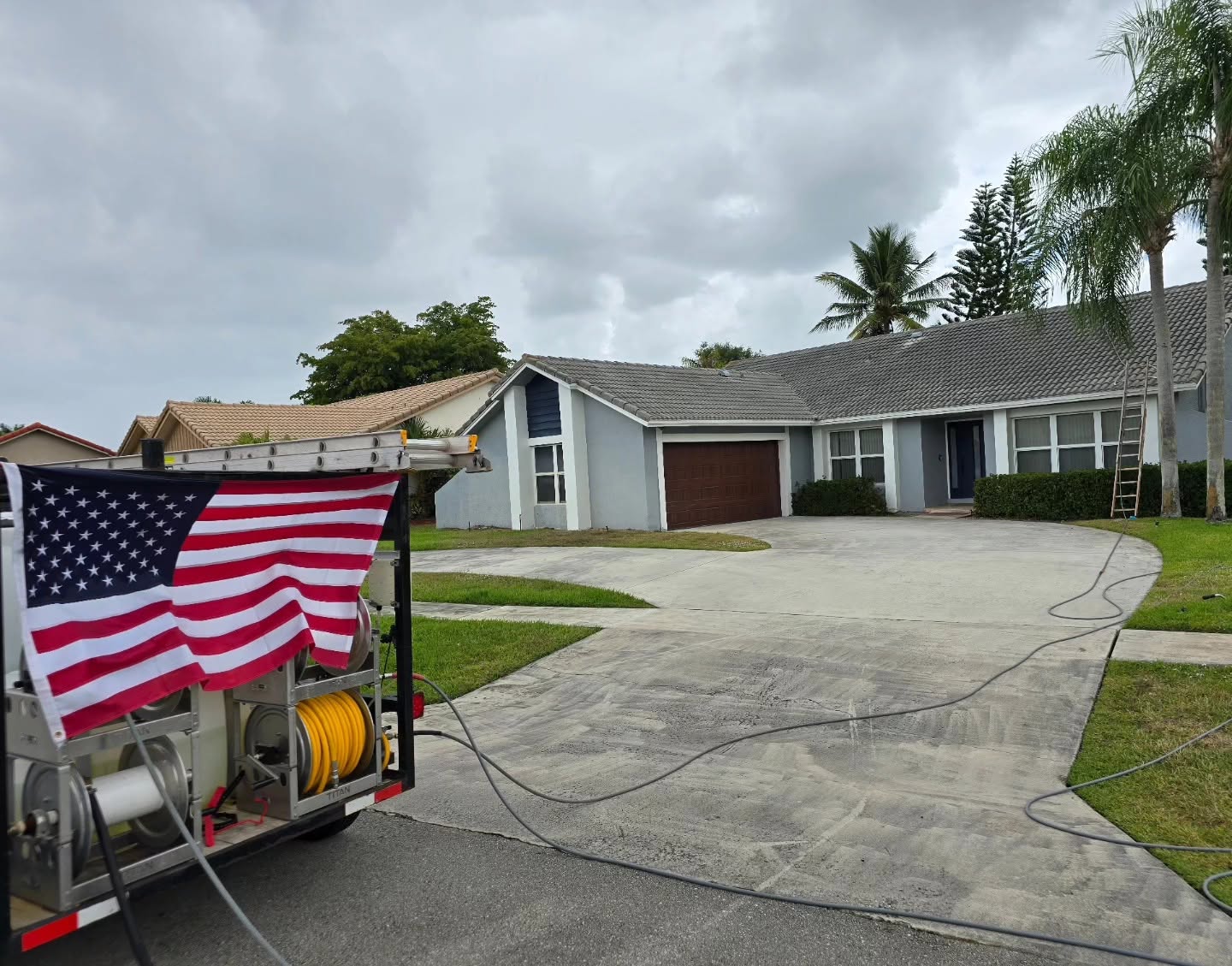 On Point Pressure Cleaning crew with USA flag on a roof job